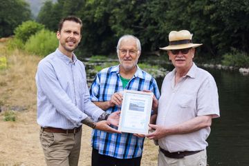Peer Cyriacks (li.), Bereichsleiter Naturschutz und biologische Vielfalt bei der DUH, übergibt die Urkunden an die "Flussbefreier" Paul Kröfges (mi.) und Friedrich Meyer (re.).