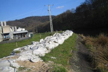 Marode Sandsäcke auf dem Deich von Haus Ley, die dort seit Jahren vor sich hingammeln.